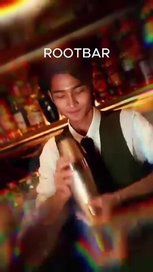 Bartender Solomon crafting a cocktail at the glowing wooden bar.