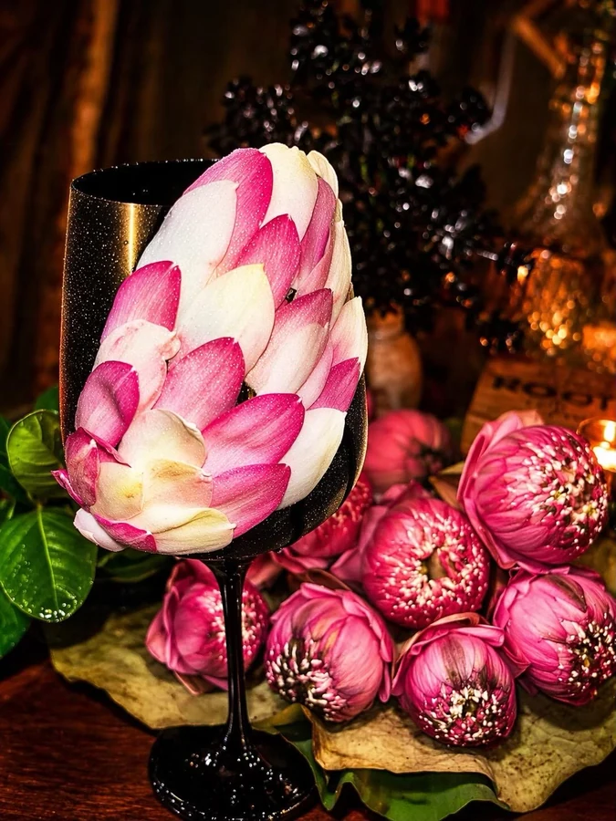 Black goblet decorated with pink lotus petals.