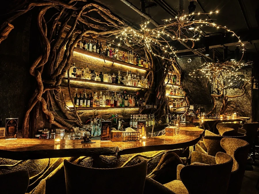 Root-framed bottle shelves and warm wooden seating inside Root Bar.