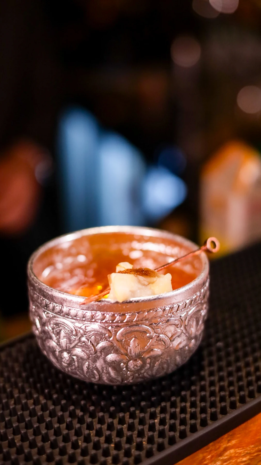 A cocktail served in an ornate rocks glass